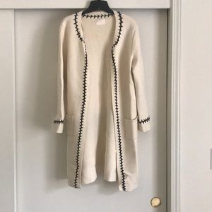 All:row cream sweater with black stitching detail